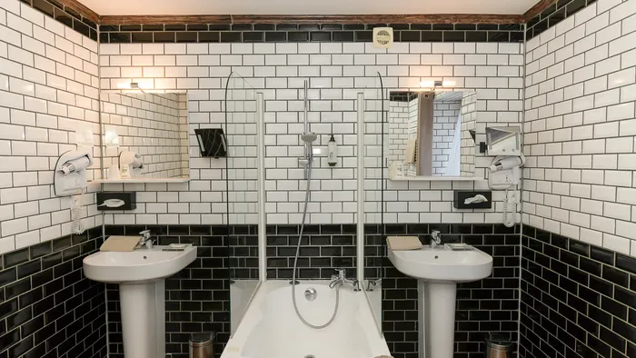 Salle de bains moderne avec deux lavabos et une baignoire à Hôtel Villa Aultia.