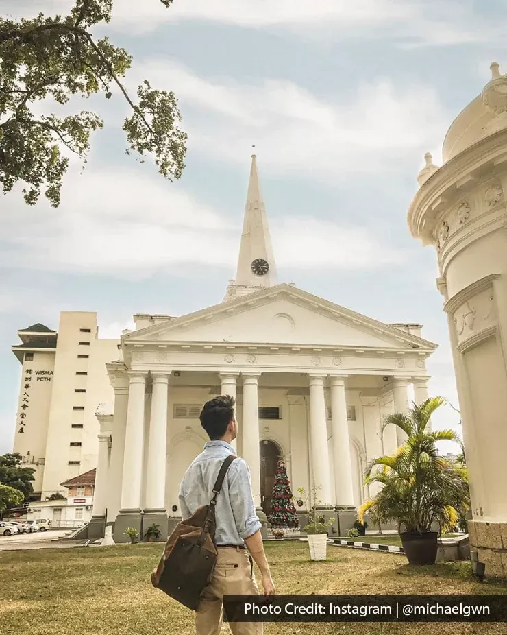 Tourist walking towards St. George’s Church historic landmark in George Town Penang Malaysia.