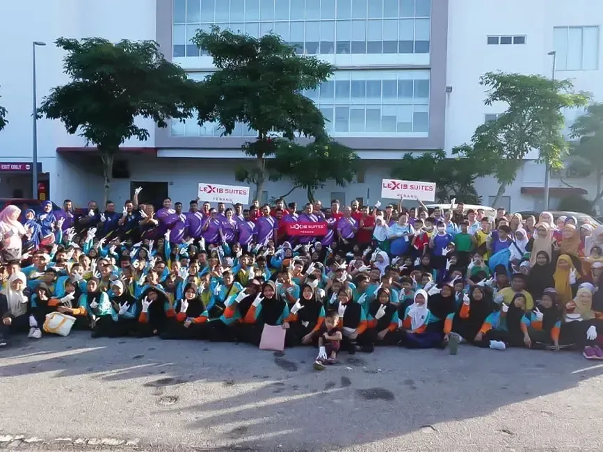 A group of people posing for the photo in front of a hotel - Lexis Hotels & Resorts