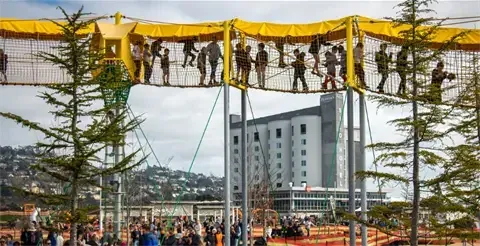 People playing on the elevated rope bridge at Launceston playground