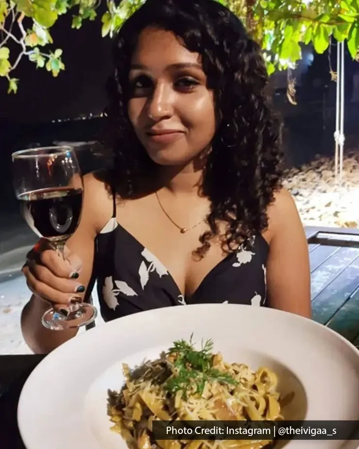 Woman enjoying pasta and red wine at Beach Blanket Babylon by the seaside.