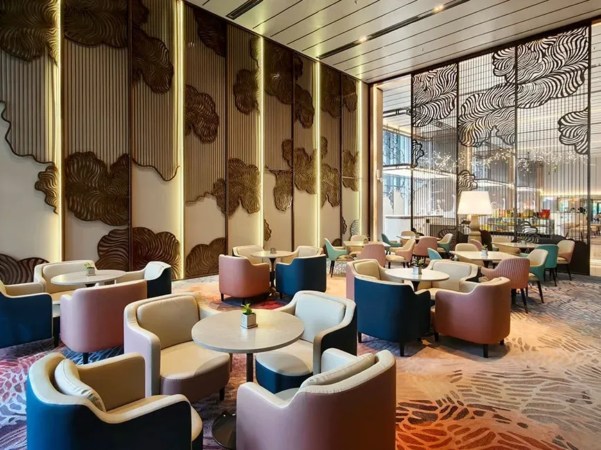 The artistic main hall of Lexis Lounge at Imperial Lexis KL featuring gold-textured walls and designer armchairs.