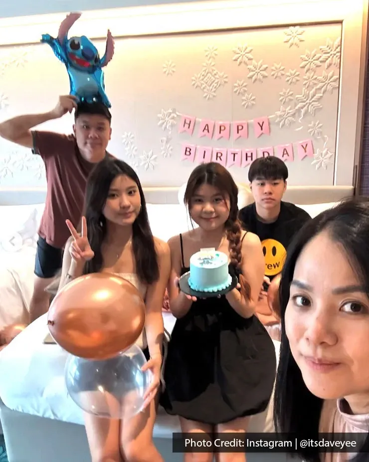 A group of friends celebrating a birthday staycation with birthday decor and cake.