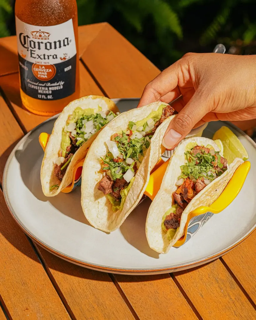 Trio of fresh steak tacos with cilantro served with a cold Corona beer at El Nogal Restaurant, Riviera Hotel South Beach