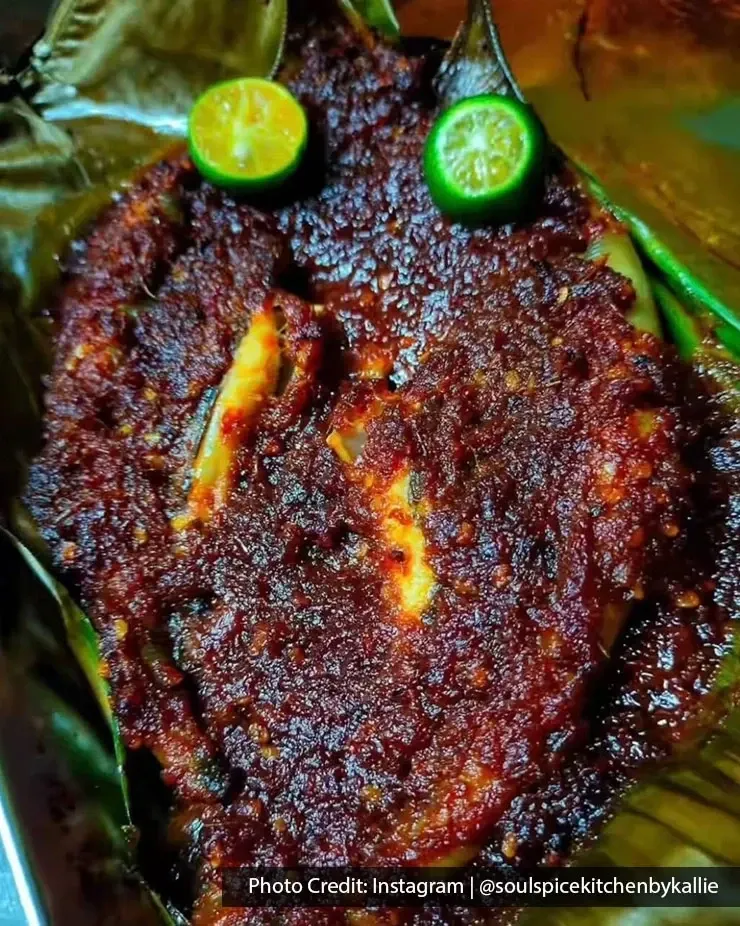 Sambal-covered grilled fish served with halved limes.