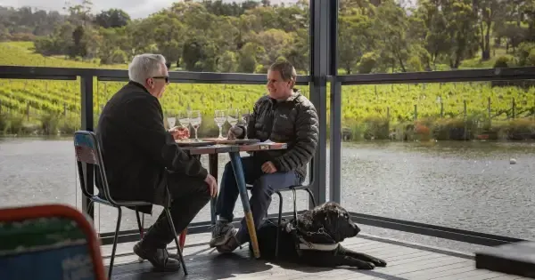 Two men enjoy a tasting by the pond at Puddleduck Vineyard.