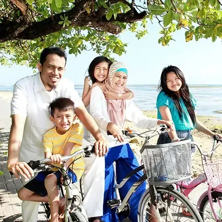 Happy family trip to Penang cycling by the beach under shady trees