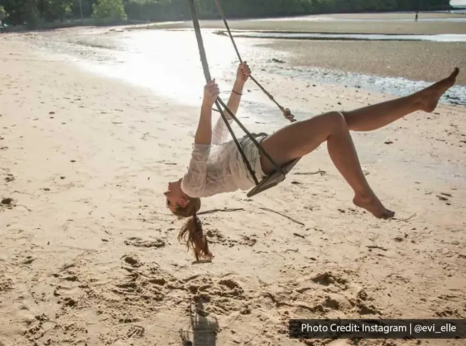 Girl swinging high at the Blue Lagoon Beach Port Dickson