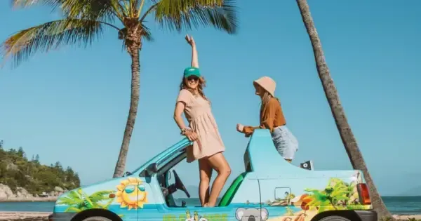 Two women pose on their colourful hire car on Magnetic Island near Townsville