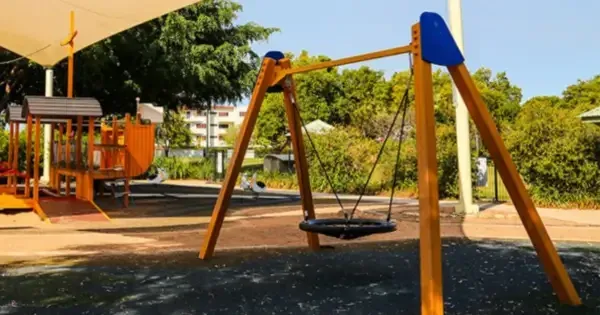 Two wooden playgrounds adjacent to each other with canopy overhead
