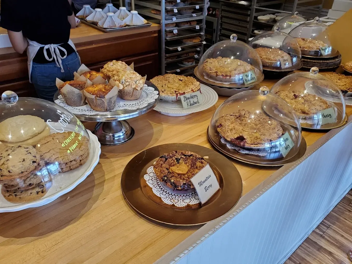 A counter with various pastries and pies on display
