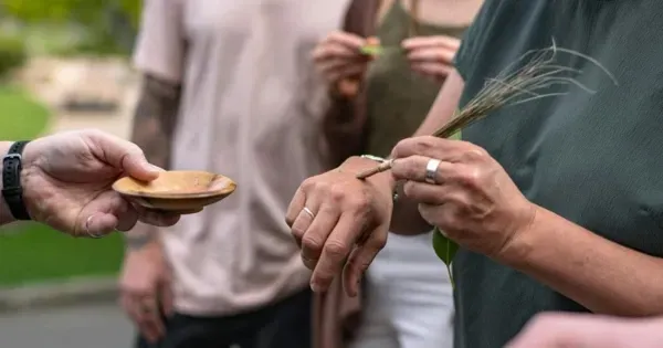 People brush their hands with ochre on a Cataract Gorge Cultural Tour