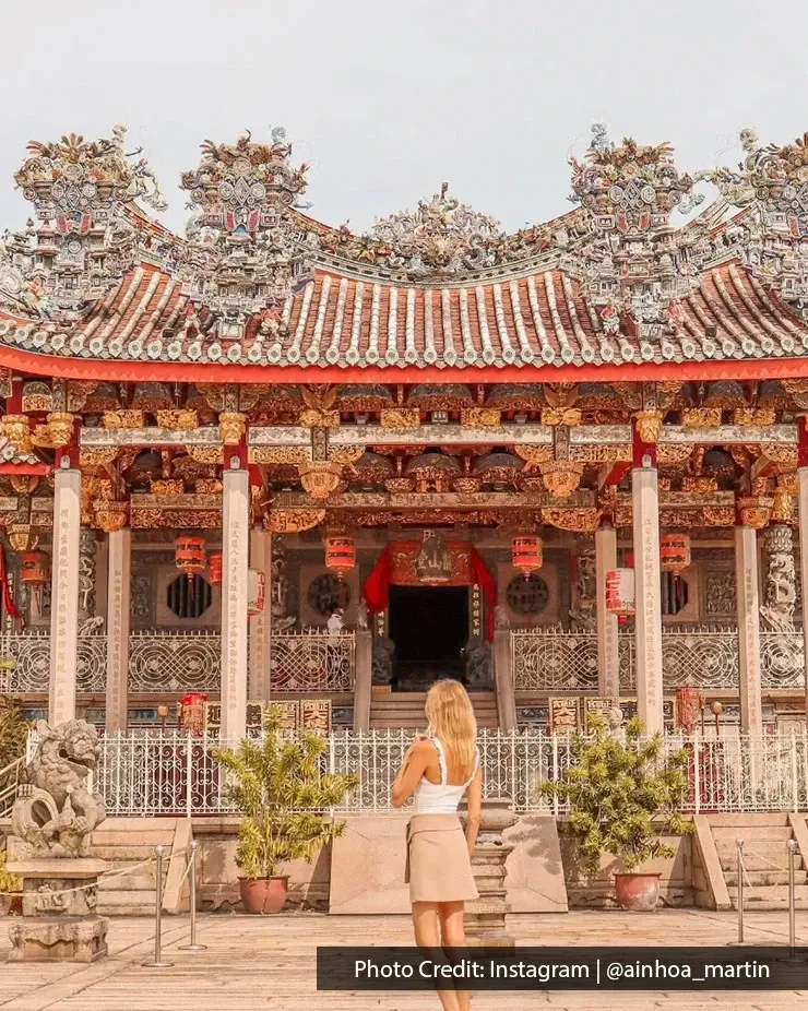 Visitor at Leong San Tong Khoo Kongsi historic courtyard with intricate architecture in Penang.