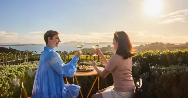 Two women enjoying a wine at Mudbrick vineyard on Waiheke Island.