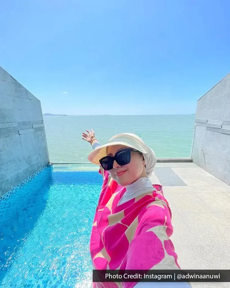 A woman posing for a picture with a private pool and sea-view background - Lexis MY