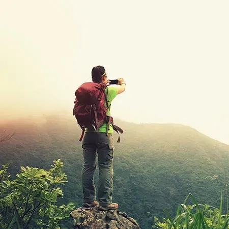 Solo traveler with red backpack  capturing mountain view - Lexis Hibiscus Port Dickson