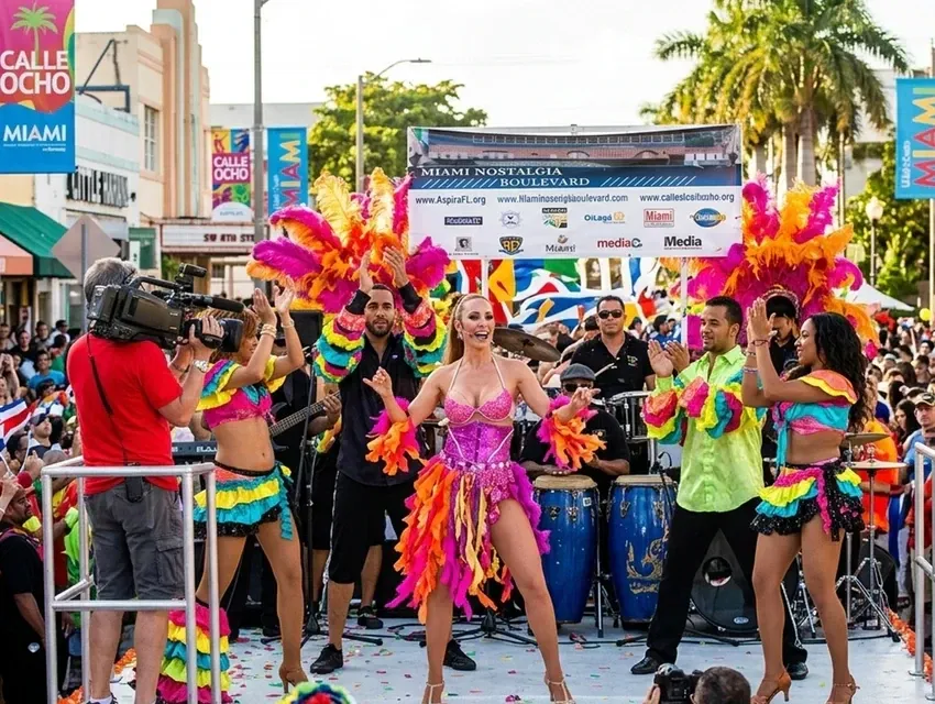 Dancers in feathered costumes performing on stage at the Calle Ocho Music Festival in Little Havana