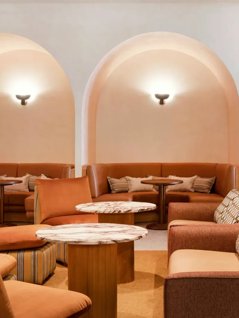 Cibaria\'s 55 North Bar at Elysium Manly with curved coral niches above leather banquettes, facing plush coral and chairs