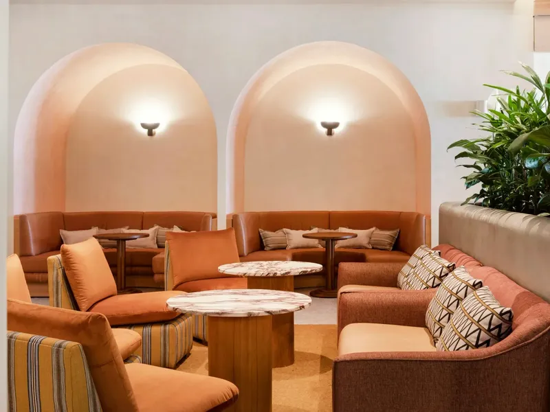 Cibaria\'s 55 North Bar at Elysium Manly with curved coral niches above leather banquettes, facing plush coral and chairs