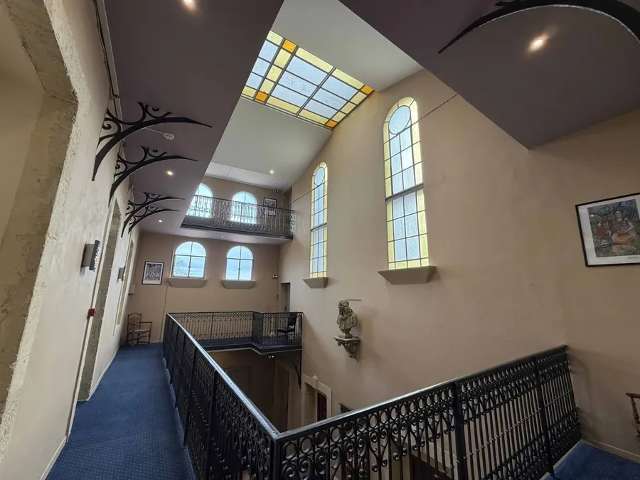 Escalier en fer forgé et hall d'entrée lumineux du Grand Hôtel Molière.