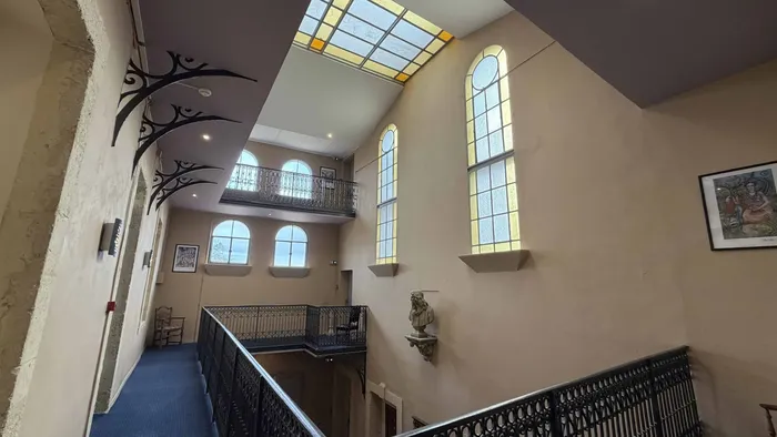 Escalier en fer forgé et hall d'entrée lumineux du Grand Hôtel Molière.