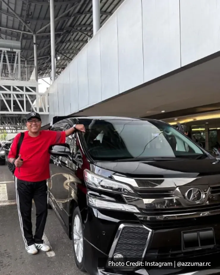 Man standing beside a black rental MPV at Penang International Airport pickup area