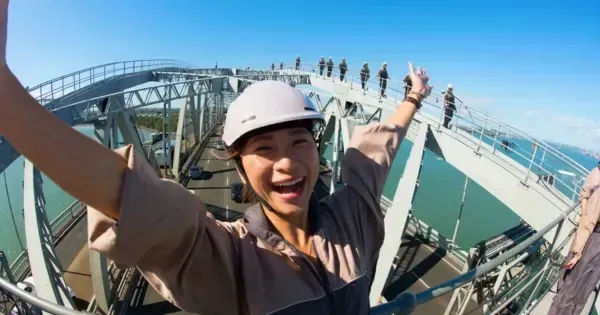 Female climber celebrates atop the Auckland Bridge