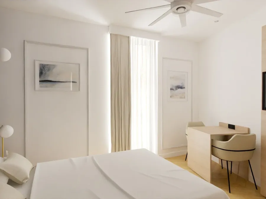 Chambre élégante avec lit, bureau et climatiseur au plafond chez Les Sources Callou.