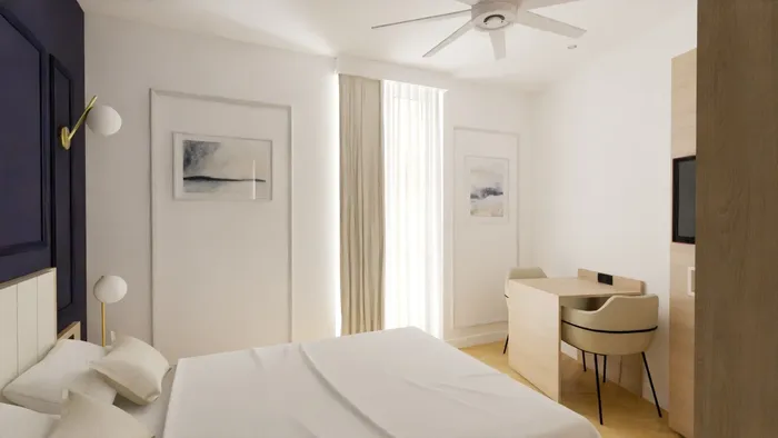 Chambre élégante avec lit, bureau et climatiseur au plafond chez Les Sources Callou.