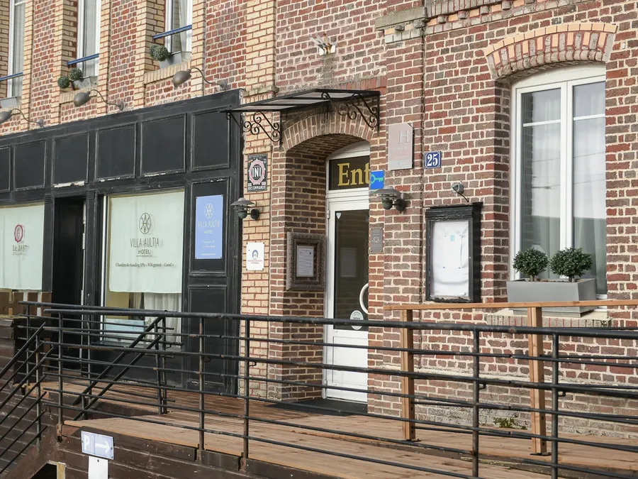 Entrée élégante de l'Hôtel Villa Aultia avec des portes en bois et une balustrade en métal noir