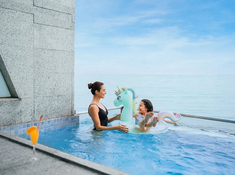 Mother and daughter relaxing in a seaside pool at Lexis Hibiscus Port Dickson