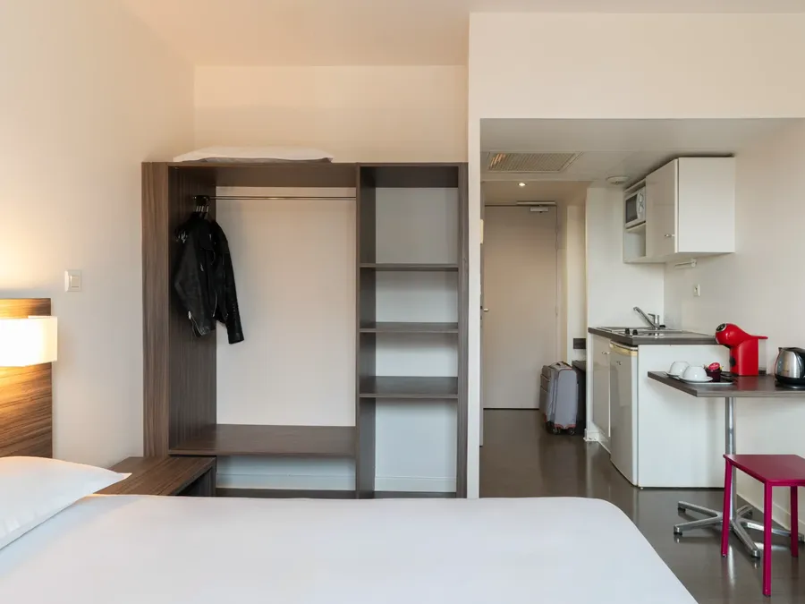 Interior of a Superior Studio with bed and kitchenette at Appart’Hôtel Hévéa in Valence.