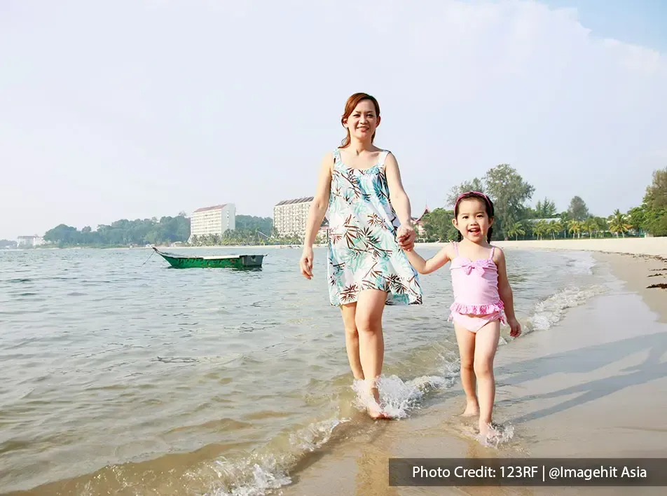 mother and daughter walking by the beach