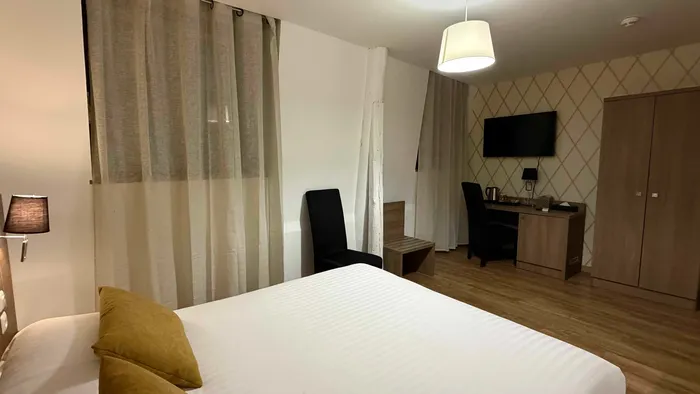 Chambre élégante avec lit double, bureau et télévision chez Le Grand Hôtel Molière.