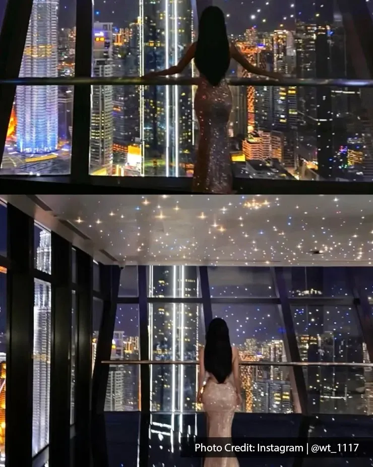 A woman poses for photo with night view of KLCC skyline in the background.