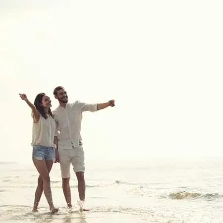 Happy couple holding hands on tropical sandy beach - Grand Lexis PD