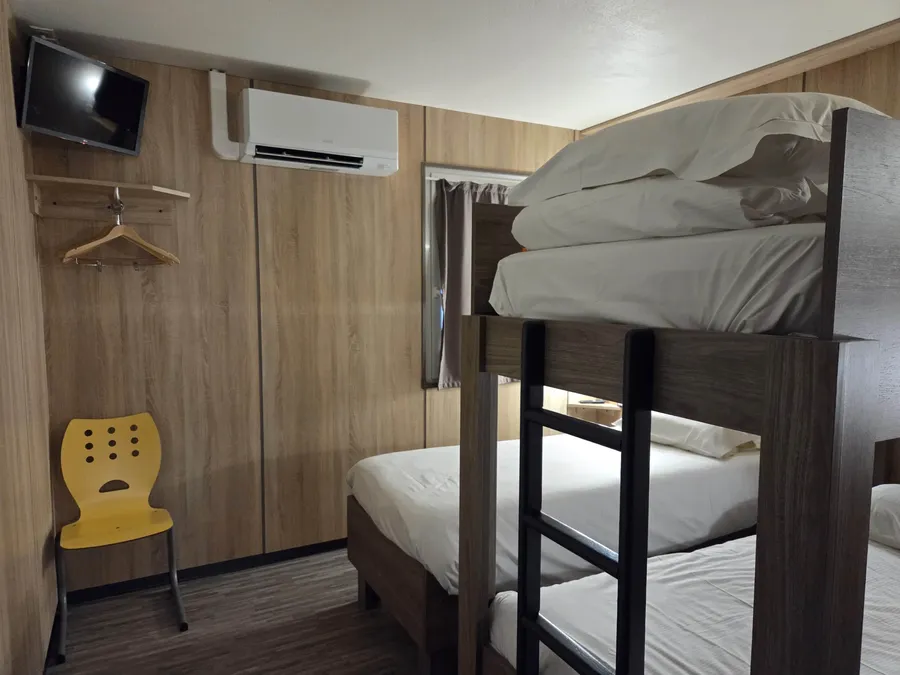 Chambre triple famille avec lits superposés et télévision à l'Hôtel Aurillac Aéroport, Aurillac.