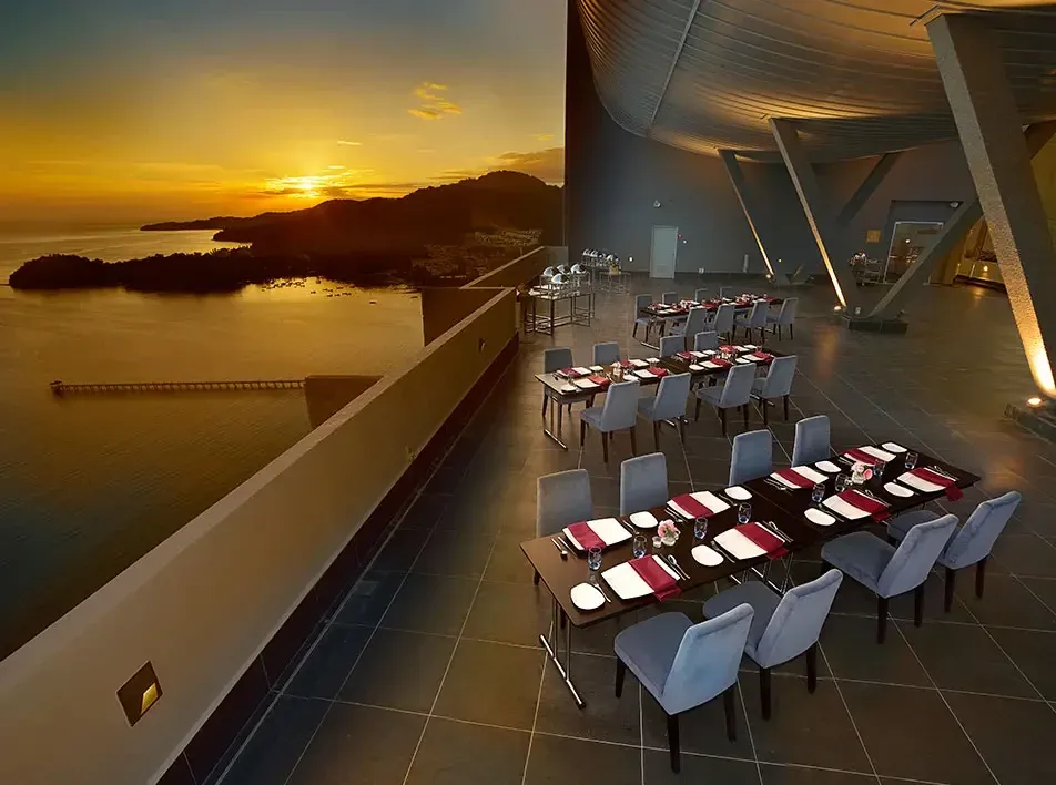 Sky Terrace outdoor dining area with ocean views at sunset.