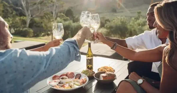 A group cheers their wine glasses at Stonyridge Vineyard, Auckland