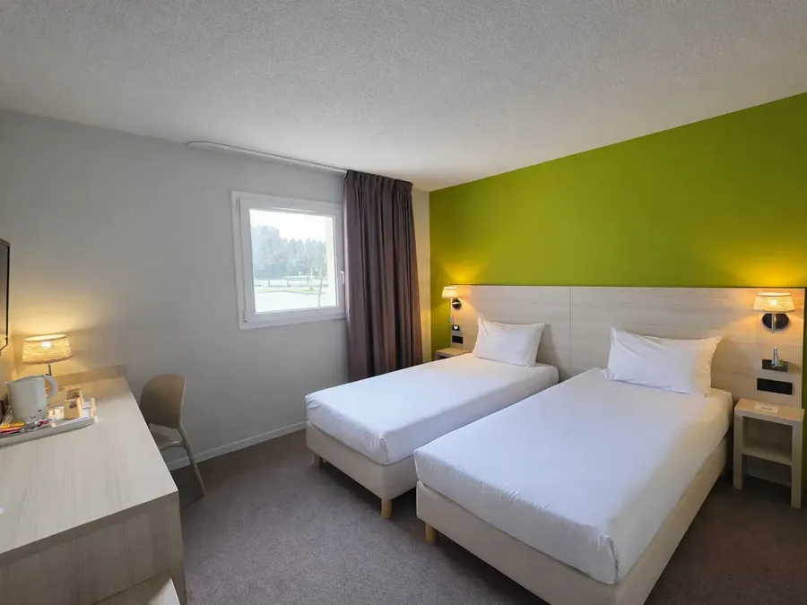 Chambre Twin avec deux lits, bureau et télévision à Hotel Les Bruyères à Castets.
