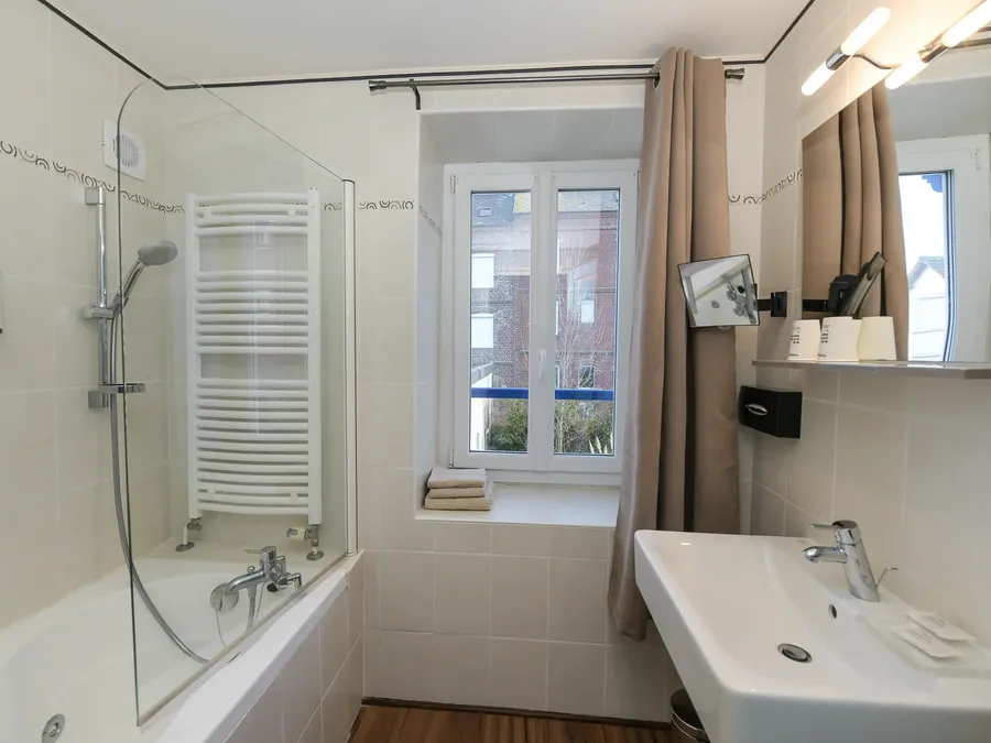 Salle de bain avec baignoire et lavabo à l'Hôtel Villa Aultia à Ault.