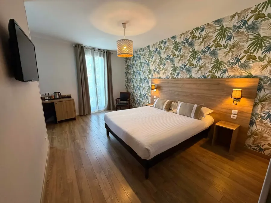 Chambre familiale avec un grand lit et décoration tropicale au Grand Hôtel Molière à Pézenas.