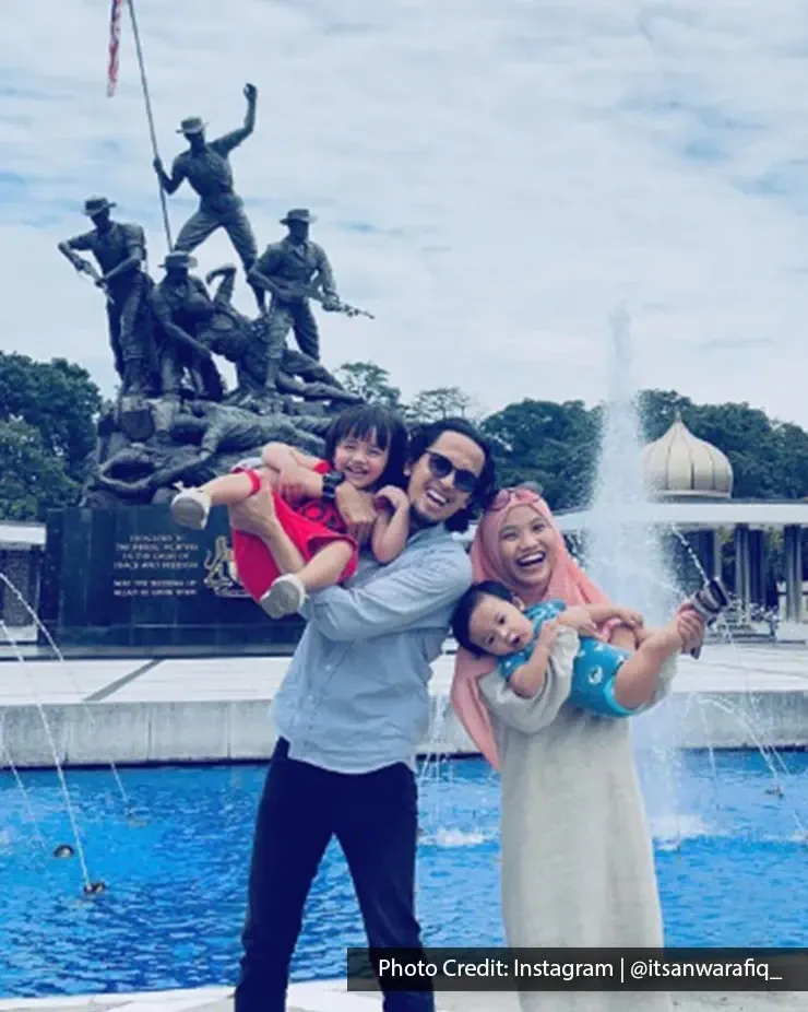 Family posing by the National Monument in Kuala Lumpur