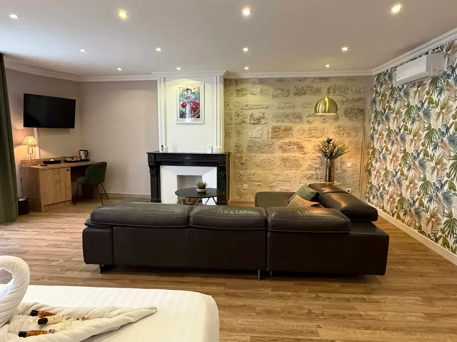 Junior Suite at Le Grand Hôtel Molière in Pézenas with a cozy living area and a bed.