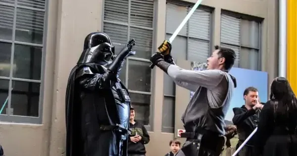 Two men in Star Wars cosplay with lightsaber.