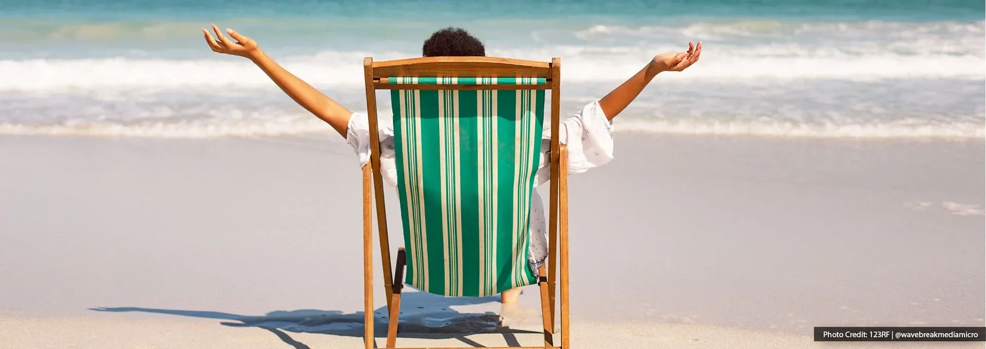 A man sitting on a beach chair, enjoying his relaxing holiday on the beach - Lexis MY