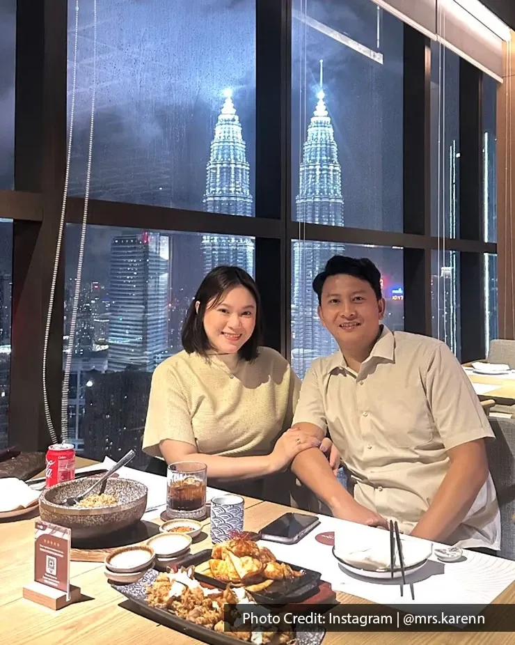 A couple posing for a photo together at a fine dining restaurant overlooking KLCC night views.