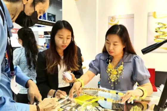 A man and woman examining jewellery pieces at an exhibition - Imperial Lexis Kuala Lumpur