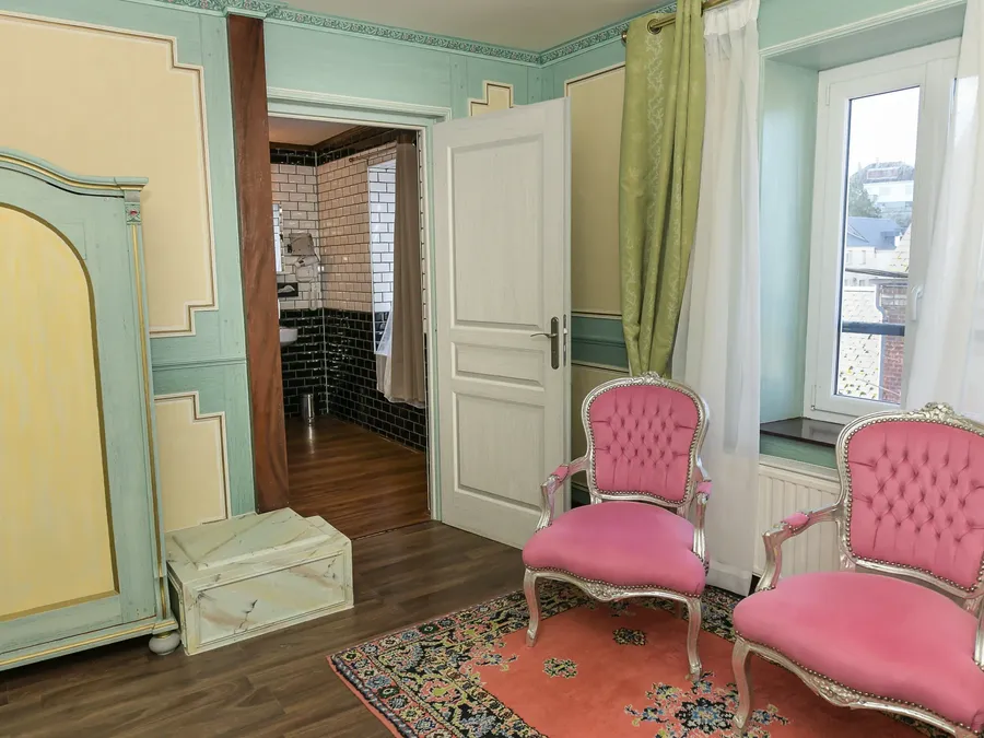 Deux fauteuils roses et un tapis coloré dans la Suite Junior à Hôtel Villa Aultia, Ault.