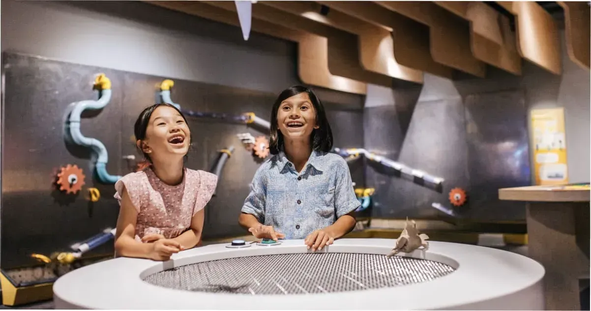Two kids enjoying an exhibit at the Queensland Museum in South Bank, Brisbane